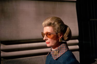 A woman with a 70s’ hairstyle and clothing walking down the street