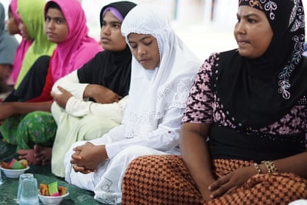 Rohingya women sit together waiting for the evening call to prayer in Aceh