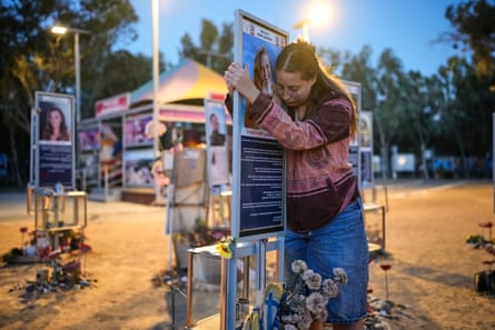 Raz Zarfati rests her head against her sister's memorial photo at the Nova festival site