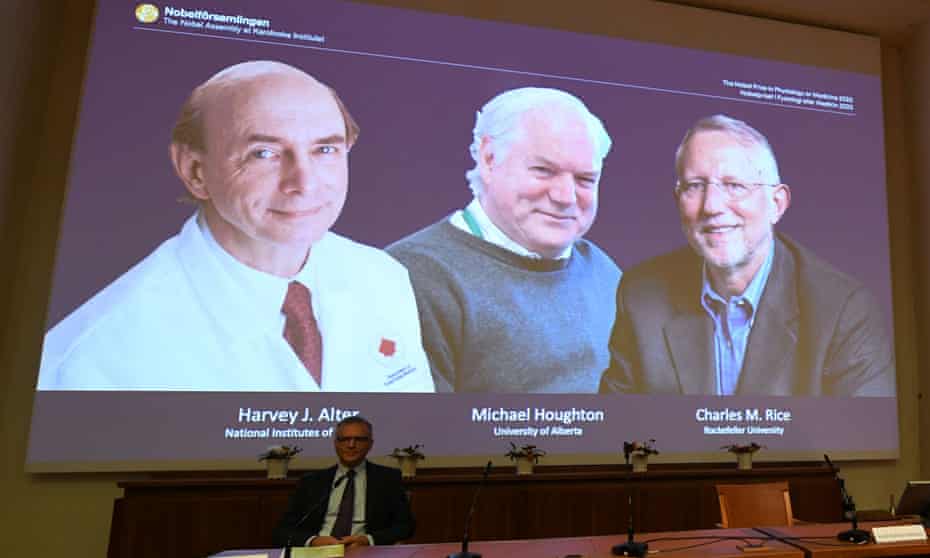 Nobel committee member Patrik Ernfors sits in front of a screen displaying the winners, (from left) Harvey Alter, Michael Houghton and Charles Rice, at the Karolinska Institute in Stockholm, Sweden