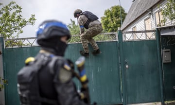 Police officers inspect a neighborhood for evacuation of civilians on a village nearby Vovchansk in Kharkiv, the scene of fierce fighting between Ukrainian and Russian forces.