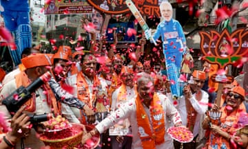 Supporters of Narendra Modi carry his cut-out as they celebrate