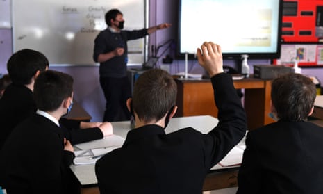 A student raises their hand in a classroom.
