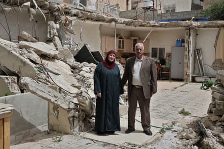 Fakhri and Amina Abu Diab stand by the rubble of their home with walls of the kitchen still standing behind them.