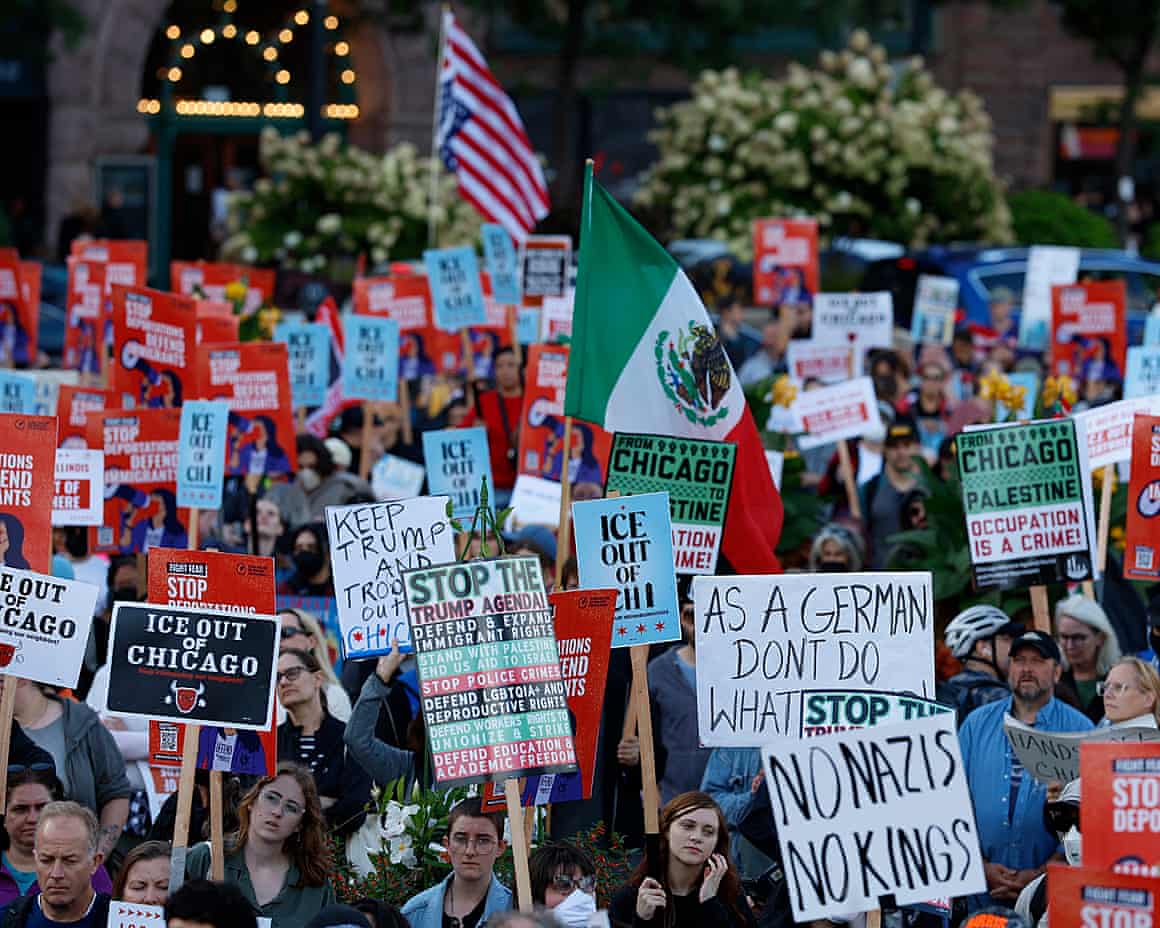 People hold placards and flags during a protest against the planned deployment of National Guard troops in Chicago, on September 6.