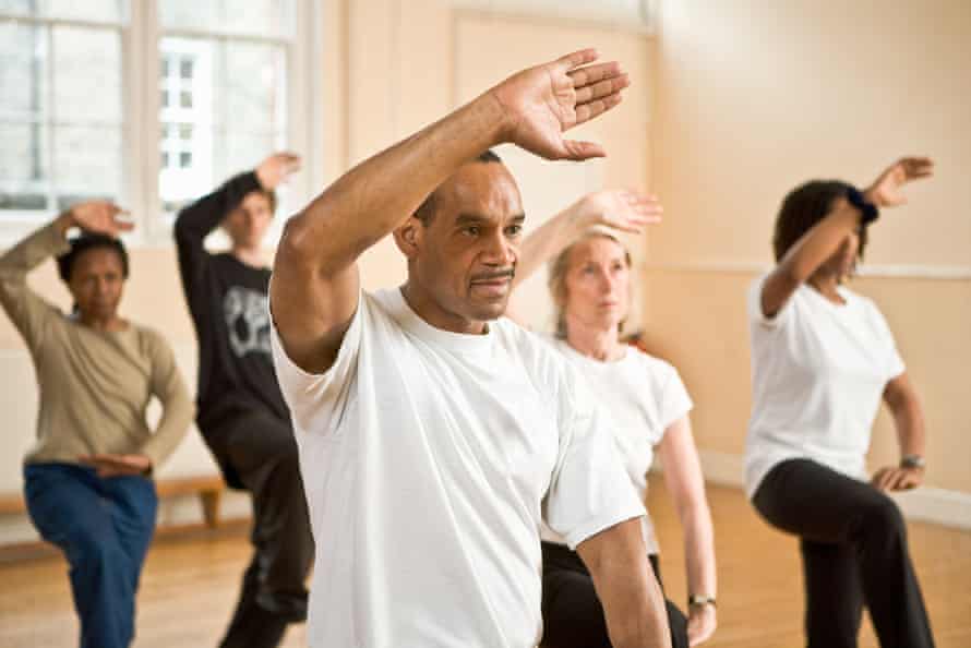 Group of people practicing posture during Tai Chi classEngland, London