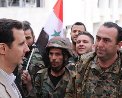 Syrian President Bashar Assad, left, talks to soldiers during his visit to the village of Maaloula, near Damascus, in April 2014