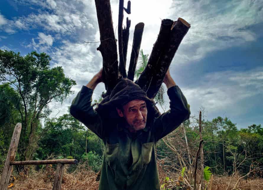 Charcoal producer Reinol Milian carries wood in San Agustin