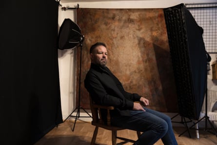 Williamson sits in his studio with photographic lights around him