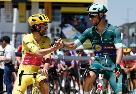 EF Education-EasyPost's Ben Healy, wearing the yellow jersey, shakes hands with Lidl-Trek's Jonathan Milan in the green jersey before stage 11.
