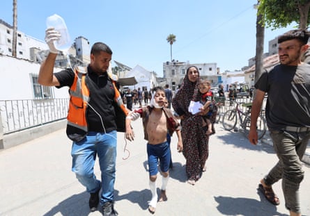 Palestinians are brought to al-Ahli Baptist hospital for medical treatment after an Israeli attack on al-Zaitun neighbourhood in Gaza City on Sunday