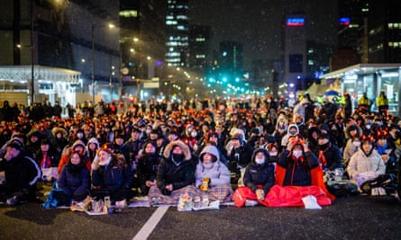 Fans of South Korea watch the match on a big screen as it snows in Seoul