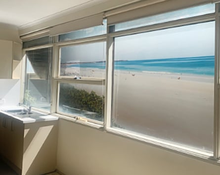 A photo from inside the unit of an apartment showing a mural of a beach out the window