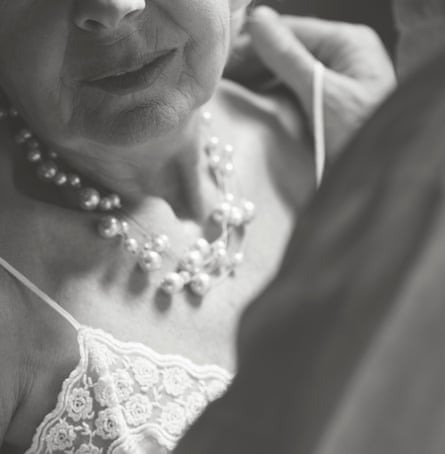 Woman with pearl necklace and hand on shoulder