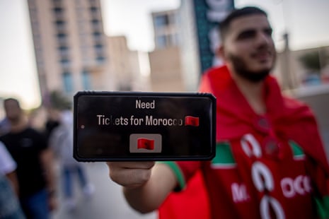 A fan of Morocco shows to photographer his mobile phone with a request for a ticket. Good luck with that, mate.