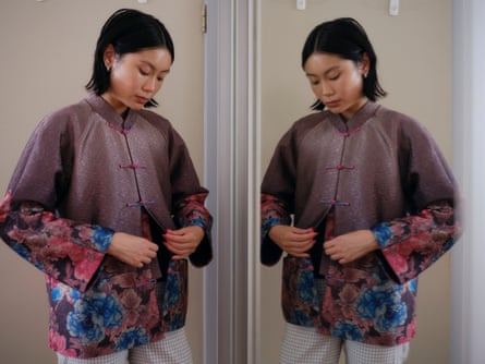 Isabella Lee is doing up her grandma’s coat facing a mirror