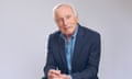 Broadcaster and author Jonathan Dimbleby sitting facing camera, hands clasped, against grey background