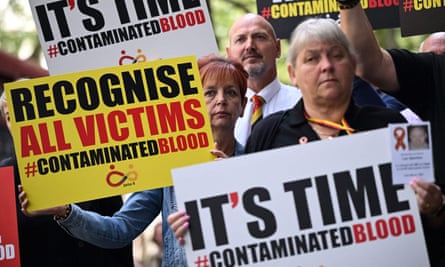 Demonstrators hold placards reading ‘It’s time #ContaminatedBlood’ and ‘Recognise all victims #ContaminatedBlood’