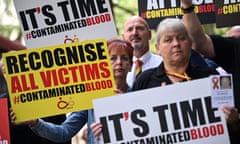 Protesters hold placards related to the infected blood scandal.