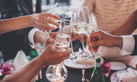 People’s hands clinking glasses at a celebratory dinner