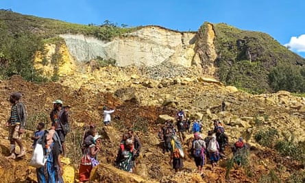 Villagers search through a landslide