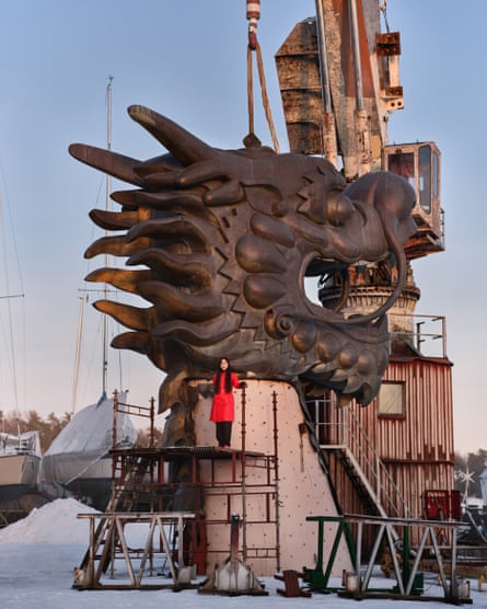 Lap-See Lam stood next to a giant dragon head sculpture