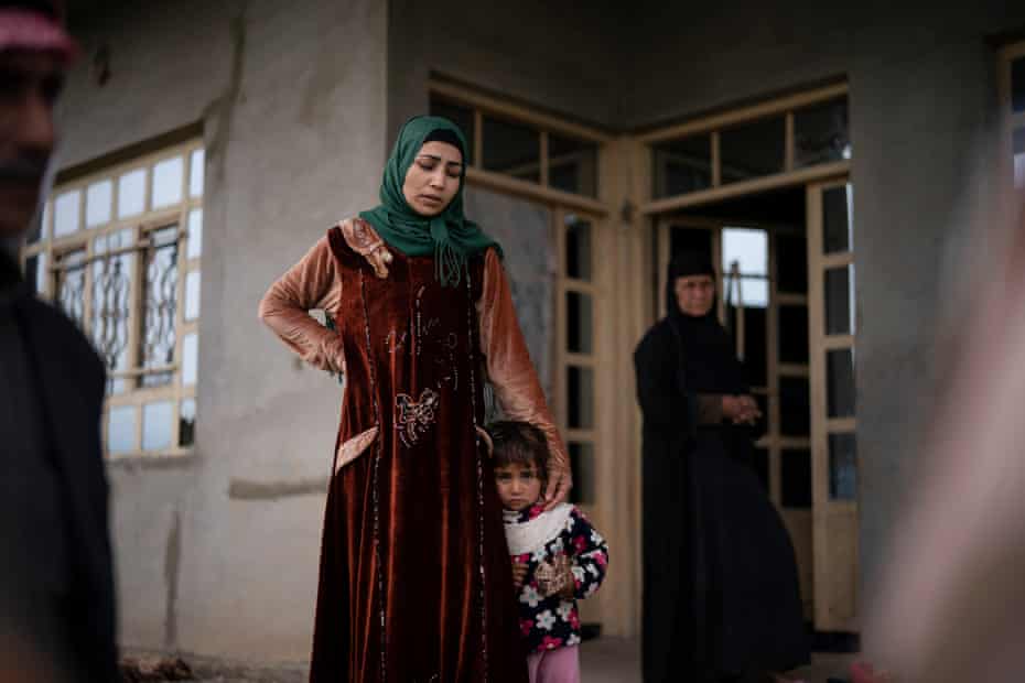 A woman holds her daughter close as she answers questions by Iraqi soldiers during a raid in Badoush, Iraq, 5 April