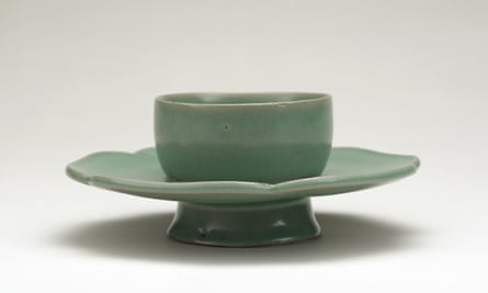 A green bowl on a green, flower-shaped stand.