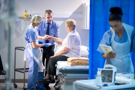 Medical staff check an elderly woman.
