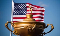 The American flag flies behind a statue of the Ryder Cup trophy