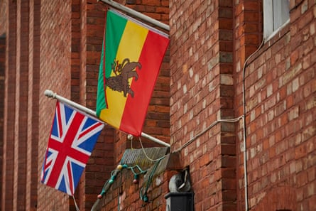 A union jack flag and a Rastafarian flag hang beside each other in Manchester.