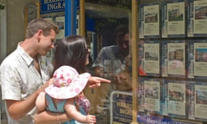 A young couple look in estate agent's window