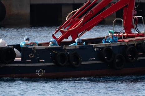 People wearing blue protective suits are evacuated on a boat from the hantavirus-stricken cruise ship MV Hondius.