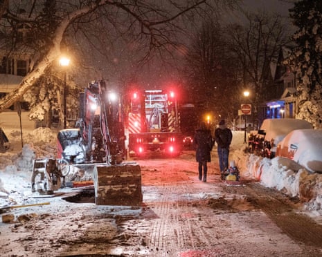 TOPSHOT-US-WEATHER-SNOW<br>TOPSHOT - Pedestrains walk past workers attempting to repair a water line in Buffalo, New York, on December 26, 2022. - Emergency crews in New York were scrambling on December 26, 2022, to rescue marooned residents from what authorities called the "blizzard of the century," a relentless storm that has left at least 25 dead in the state and is causing US Christmas travel chaos. (Photo by Joed Viera / AFP) (Photo by JOED VIERA/AFP via Getty Images)