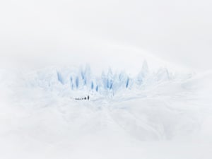 Human figures dwarfed by a glacier
