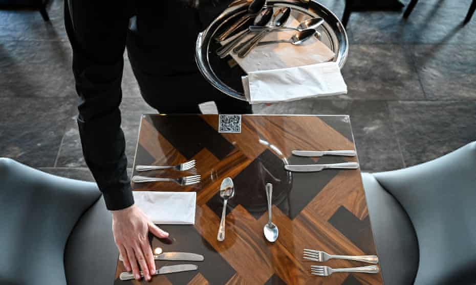 A member of staff prepares a table at a restaurant