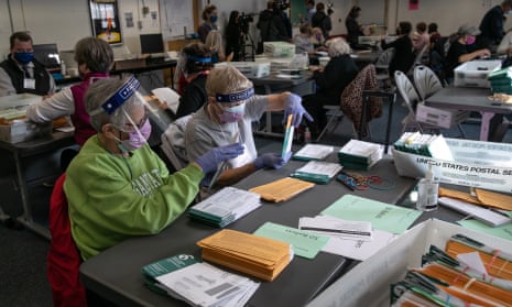 Election workers sort absentee ballot envelopes at the Lansing city clerk’s office in Michigan on Monday.