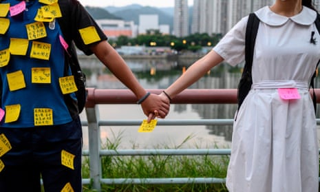 Students put memos on their uniforms as they take part in a human chain event in Sha Tin district in Hong Kong 