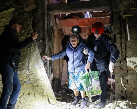 A policeman helps an elderly woman to walk out from a residential building damaged by a Russian airstrike in Zaporizhzhia, Ukraine.