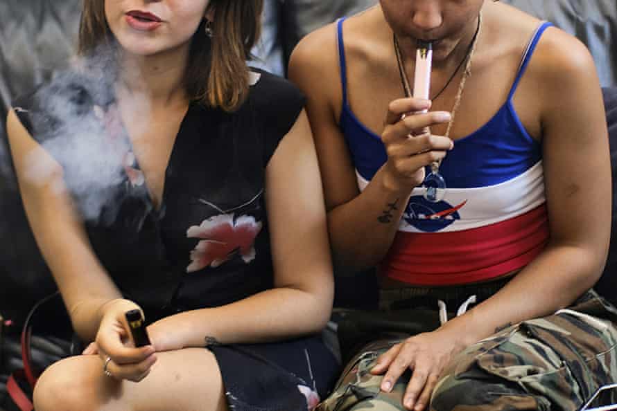 Two women smoke cannabis vape pens at a party in Los Angeles in 2019.