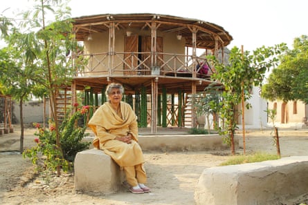 Yasmeen Lari sits in front of one of her circular carbon-neutral houses in Pakistan