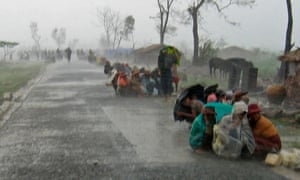 Cyclone victims in Myanmar huddle in torrential rain as they await assistance after Cyclone Nargis