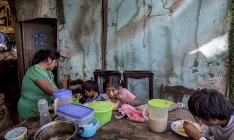 Consuelo Pascacio’s three children; Estiben 4, Estefany, 11, and Javier, 14, dig into a chicken rice stew she picked up at a “community pot,” in their home in the Nueva Esperanza neighborhood of Lima, Peru, on Monday, 8 June, 2020. For many residents the “community pot” is their only defense against a hunger that’s become a constant feature of life amid the new coronavirus pandemic.
