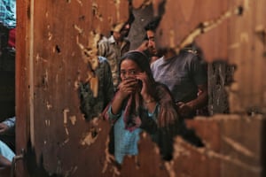 A Kashmiri woman inspects a house damaged during clashes between militants and Indian forces in the Danmar area of Srinagar