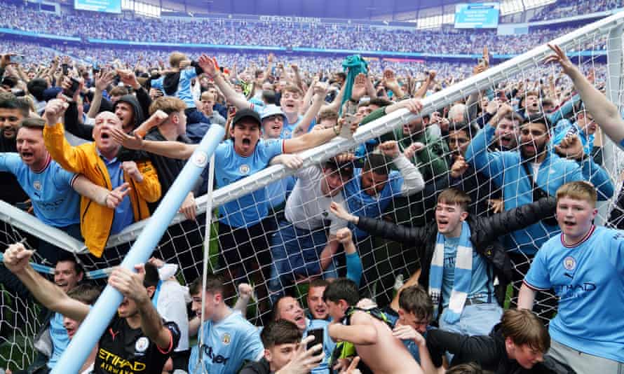 Manchester City fans invade the pitch after their side won the Premier League with a 3-2 victory against Aston Villa at the Etihad Stadium.