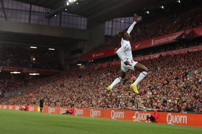Zaha leaps into the air in celebration.