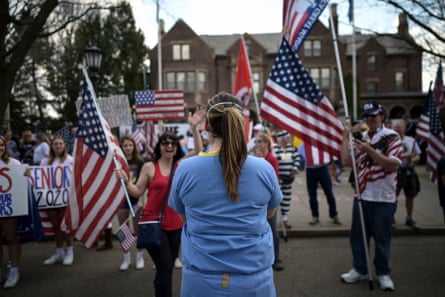 A registered nurse stands in front of protestors rallying outside of the Minnesota governor’s mansion to demand an end to the coronavirus lockdown.