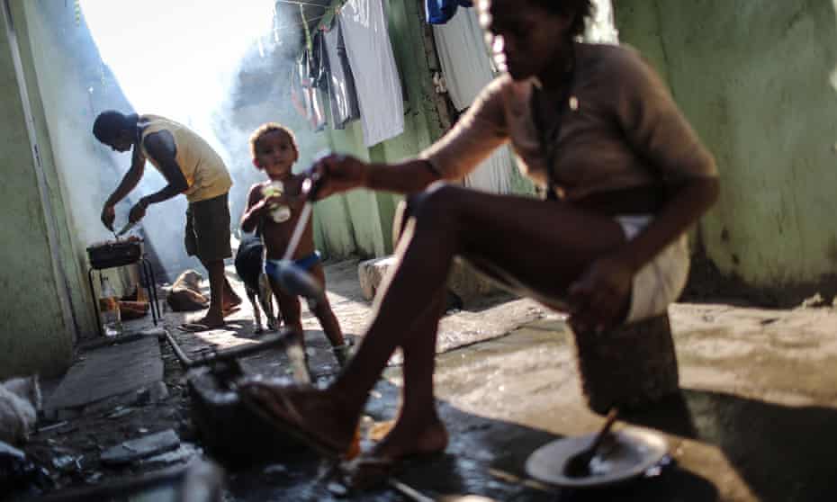 A man cooks a meal in Maré favela. ‘We still don’t have what is most important: peace.’