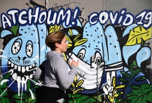 Parigi, Francia Un jogger passa un murale con un messaggio che dice "Achoo Covid-19"