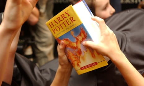 A child's hands hold a copy of Harry Potter and the Order of the Phoenix